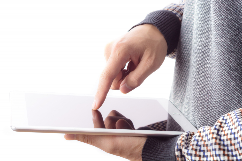 Person tapping on a tablet screen against a white background