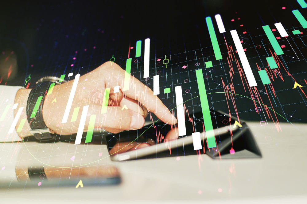 Trader using a tablet with digital forex and stock market charts overlay.